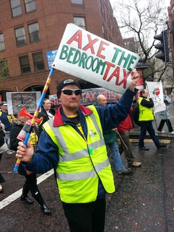 A man holding a banner saying Axe the Bedroom Tax at the protest on 5 April. 